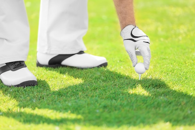 Jeune homme jouant au golf sur un parcours en journée ensoleillée