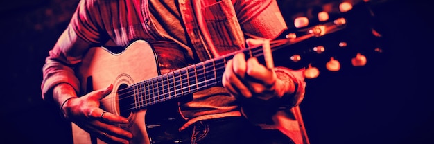 Jeune homme jouant de la guitare au pub