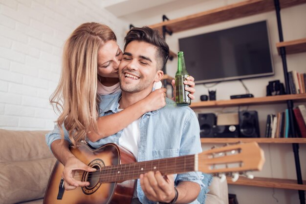 Jeune homme jouant de la guitare sa fille dans le salon