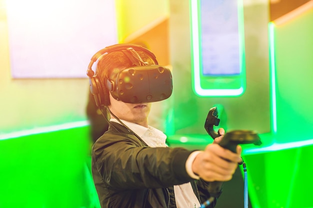 Jeune homme jouant à des jeux vidéo lunettes de réalité virtuelle homme joyeux s'amusant avec les nouvelles tendances