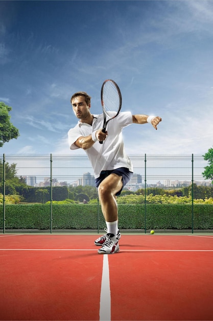 Le jeune homme joue au tennis le jour ensoleillé