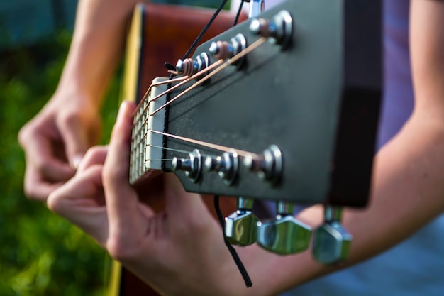 Un jeune homme joue de la guitare à l'air frais