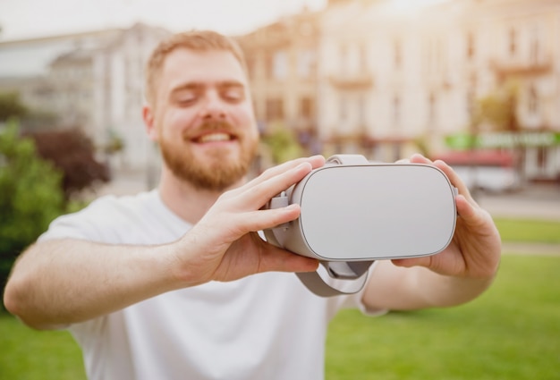 Un jeune homme joue à un jeu avec des lunettes de réalité virtuelle dans la rue.