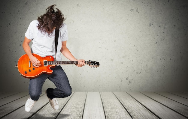 Jeune homme jouer de la guitare sur fond