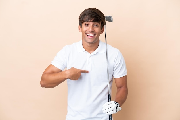 Jeune homme de joueur de golfeur isolé sur fond ocre avec une expression faciale surprise