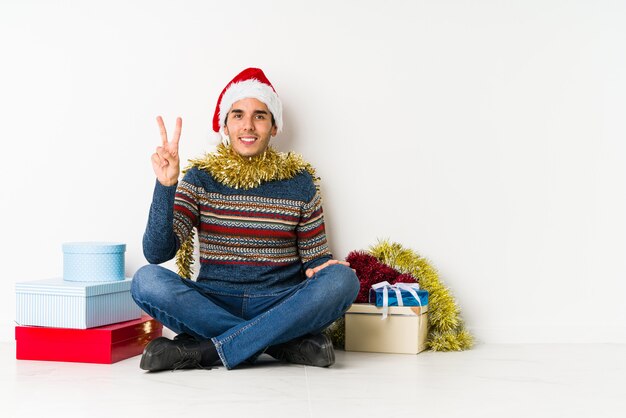 Jeune homme le jour de Noël confiant en gardant les mains sur les hanches.