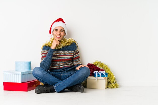 Jeune homme le jour de Noël doutant entre deux options.