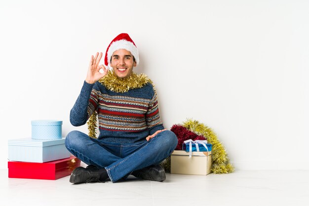 Jeune homme le jour de Noël, étirement des bras, position détendue.