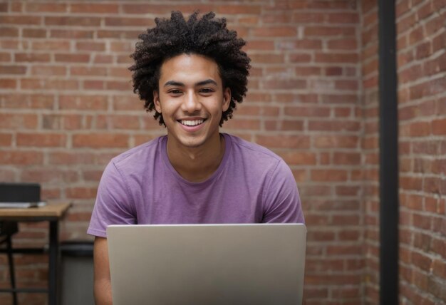 Un jeune homme joyeux aux cheveux bouclés utilisant un ordinateur portable exhalant le bonheur et le professionnalisme décontracté