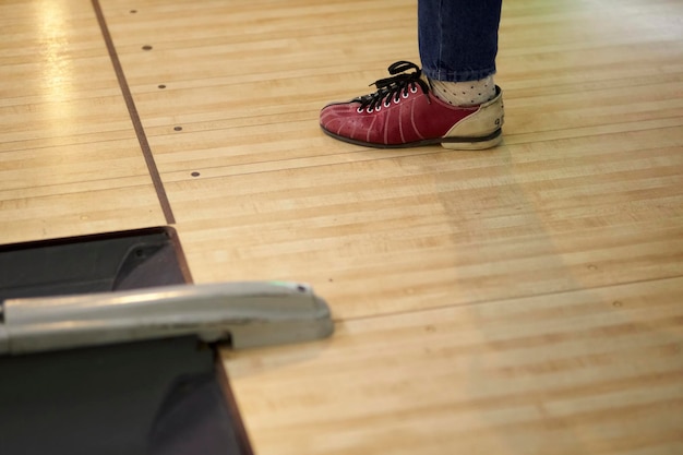 Jeune homme laçant ses chaussures dans un club de bowling libre