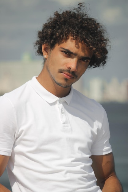 Un Jeune Homme Latin Sur La Côte Portant Des T-shirts Blancs