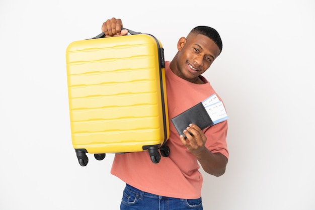 Jeune homme latin isolé en vacances avec valise et passeport