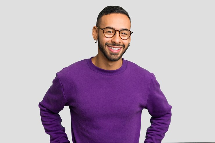 Photo jeune homme latin portant des boucles d'oreilles isolé confiant gardant les mains sur les hanches