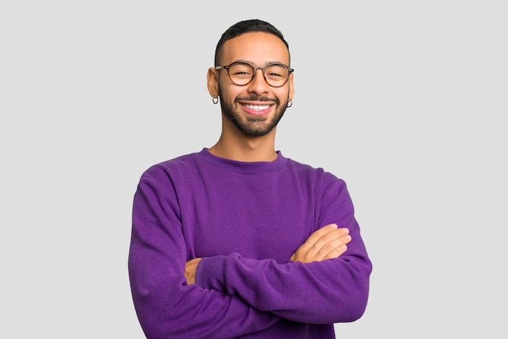 Photo jeune homme latin portant des boucles d'oreilles isolé qui se sent confiant croisant les bras avec détermination