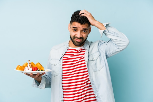 Jeune homme latin tenant une gaufre