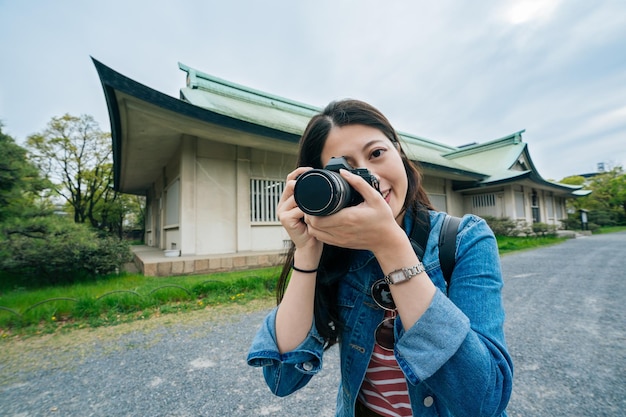 jeune homme de lentille de tourisme prenant une photo par la caméra en souriant. joyeux photographe professionnel attrayant à l'aide d'un appareil photo numérique. belle fille aime la photographie voyage en plein air en été.