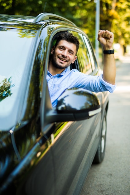 Jeune homme levant son poing de la voiture