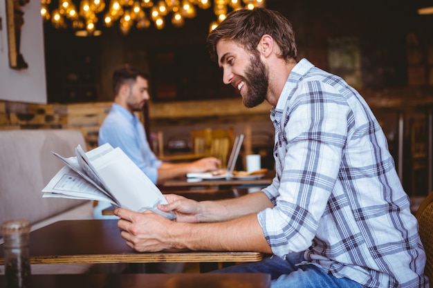 Jeune homme lisant un journal