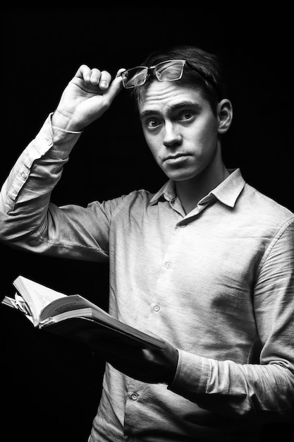 Jeune homme avec un livre couvrant son visage