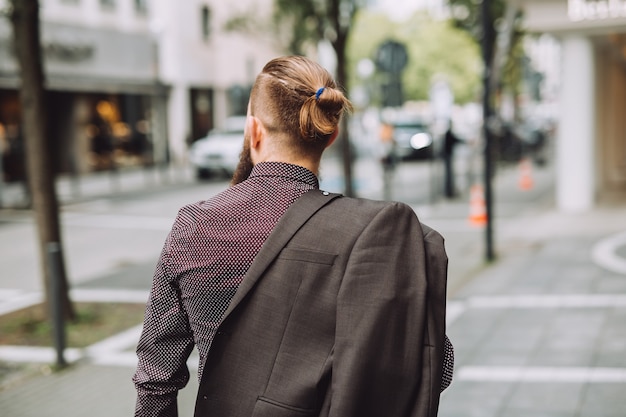 Jeune homme à longue barbe dans la rue de la ville.