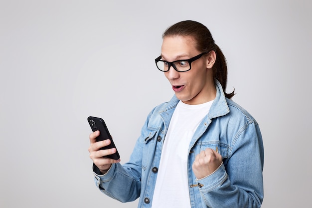 Jeune homme à lunettes à l'aide d'un téléphone intelligent