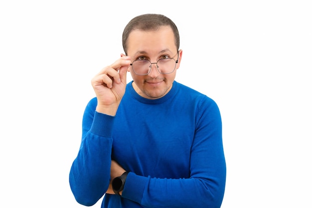 Jeune homme à lunettes et un chandail bleu regardant la caméra sur un fond blanc