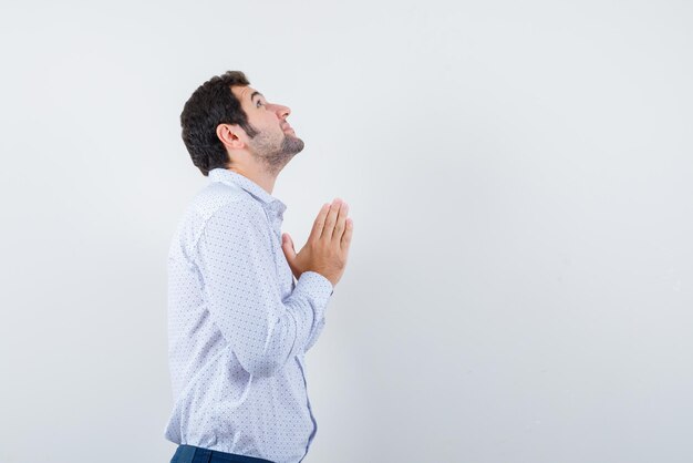 Jeune Homme Avec Les Mains En Prière Sur Fond Blanc