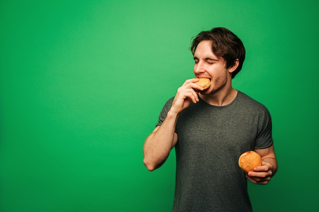 Jeune Homme Mange Un Beignet Avec Plaisir