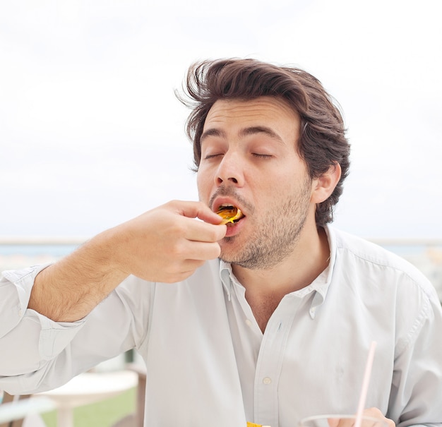 Jeune homme mangeant des chips