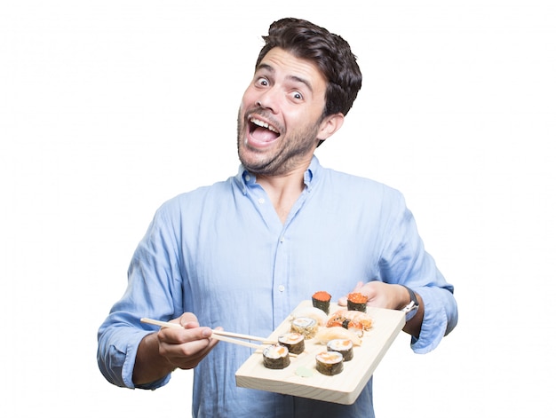 Jeune homme manger des sushis sur fond blanc