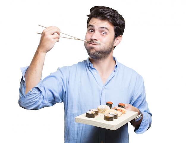 Jeune homme manger des sushis sur fond blanc