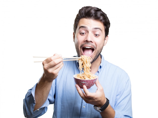 Jeune homme manger des sushis sur fond blanc