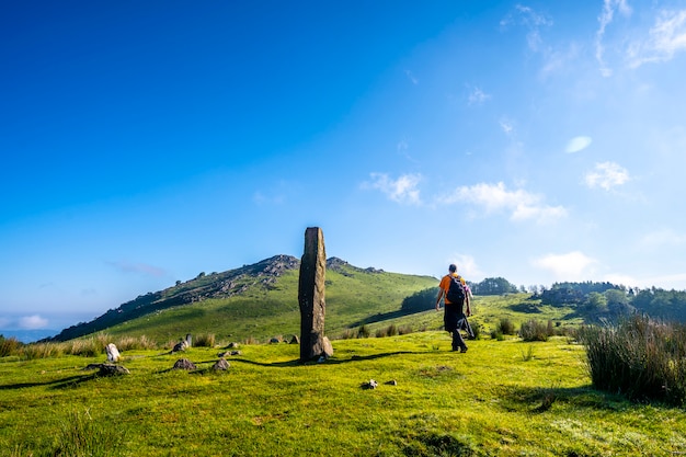 Un jeune homme marchant le long d'un dolmen préhistorique au sommet du mont Adarra à Urnieta, près de Saint-Sébastien. Gipuzkoa, Pays Basque