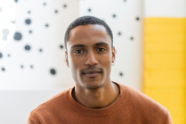 Jeune homme marocain avec un regard magnétique regardant la caméra Portrait en studio d'un charmant jeune homme du Moyen-Orient sur un fond jaune et blanc Copier l'espace pour le texte