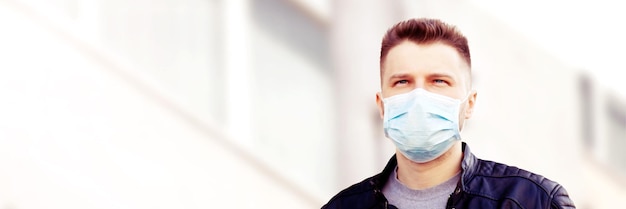 Jeune homme en masque facial stérile contre le virus corona.