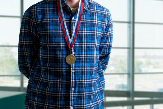 Un jeune homme avec une médaille d'or sur la poitrine, réalisation personnelle et succès