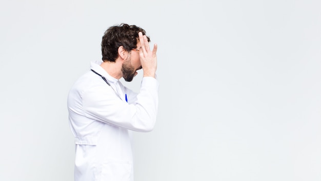 Jeune homme médecin barbu fou contre le mur de l'espace de copie