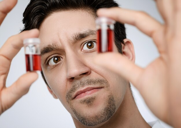 Jeune homme médecin ou chercheur détient des échantillons liquides