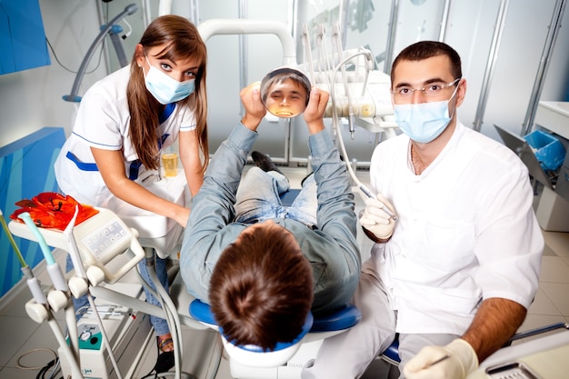 Jeune homme médecin dentiste en uniforme blanc et masque spécial