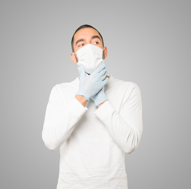 Jeune homme médecin portant un masque et des gants de protection