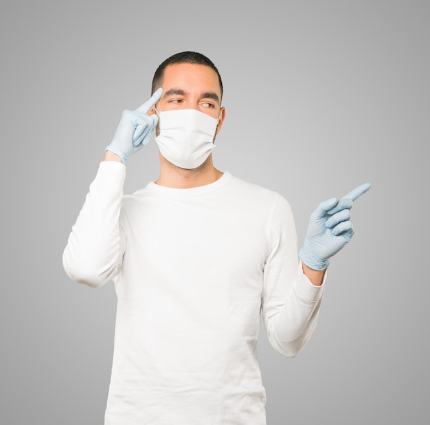 Jeune homme médecin portant un masque et des gants de protection