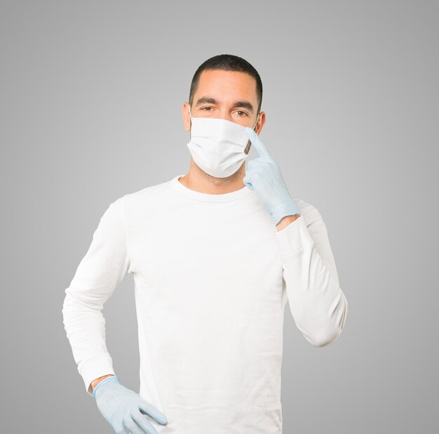 Jeune homme médecin portant un masque et des gants de protection