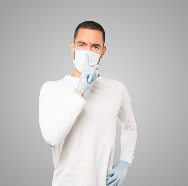 Jeune homme médecin portant un masque et des gants de protection