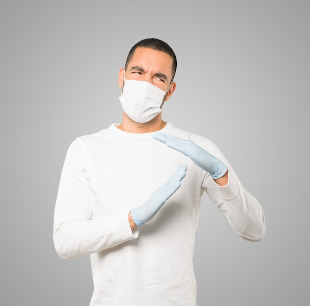 Jeune homme médecin portant un masque et des gants de protection