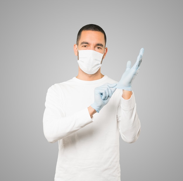 Jeune homme médecin portant un masque et des gants de protection