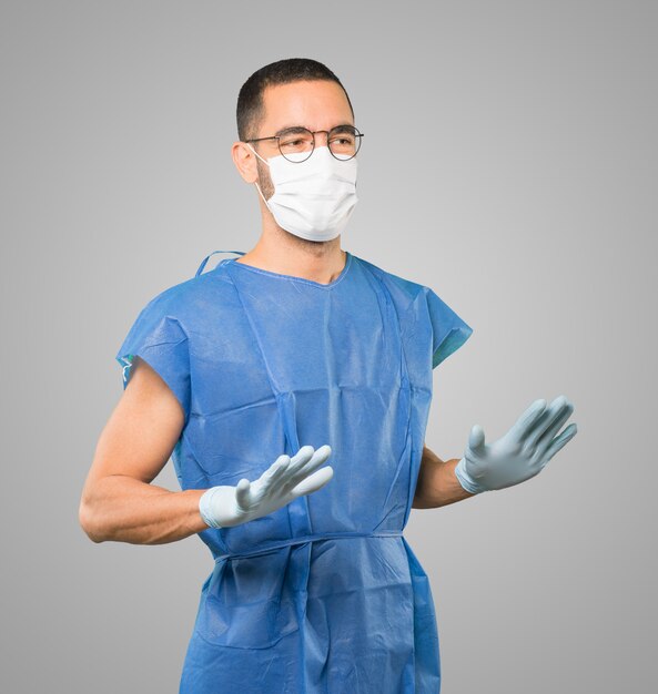 Jeune homme médecin portant un masque et des gants de protection