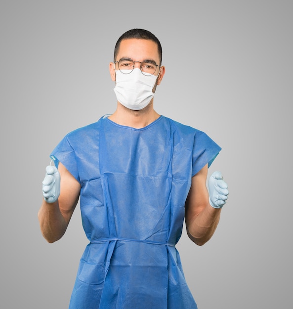 Jeune homme médecin portant un masque et des gants de protection