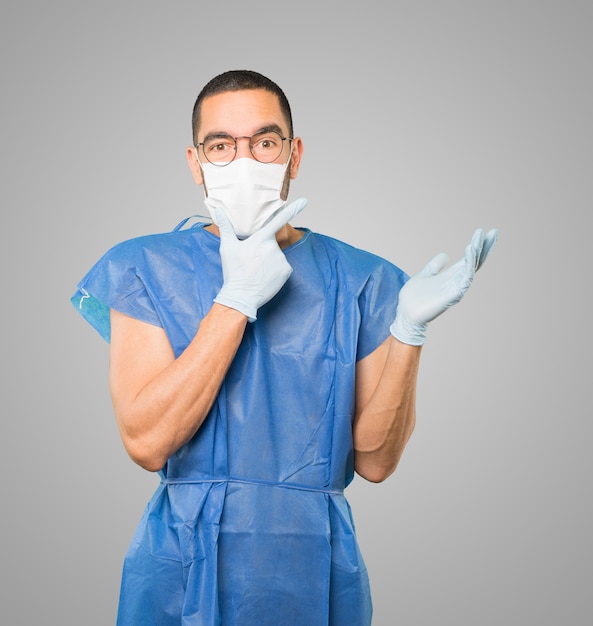 Jeune homme médecin portant un masque et des gants de protection