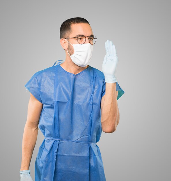 Jeune homme médecin portant un masque et des gants de protection