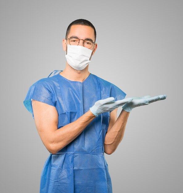 Jeune homme médecin portant un masque et des gants de protection